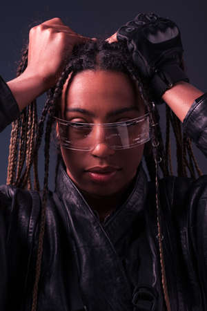 Portrait of stylish african american woman using smart glasses isolated on dark greyの写真素材