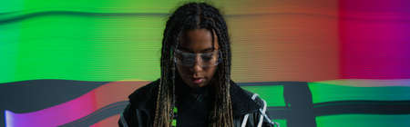 African american woman in smart glasses standing on colorful abstracted background, banner