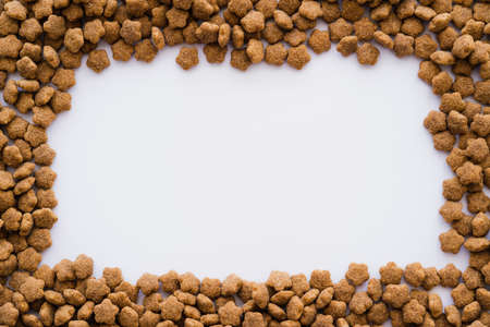 flat lay of frame with dry pet food isolated on whiteの写真素材