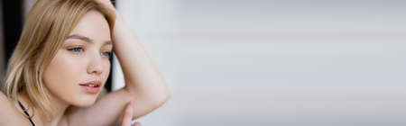 Pretty blonde woman looking away at home, banner