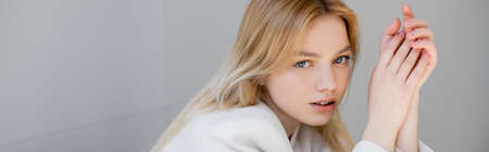 Woman in white jacket looking at camera at home, bannerの写真素材