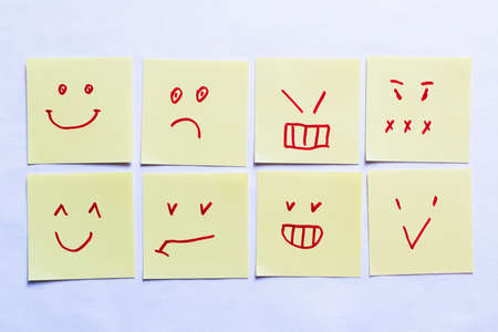 top view of sticky notes with positive and negative smileys on white backgroundの写真素材