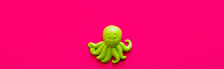 top view of bright green octopus toy on pink background, bannerの写真素材