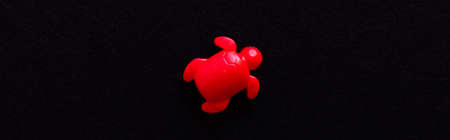 top view of red aquatic turtle toy isolated on black, bannerの写真素材