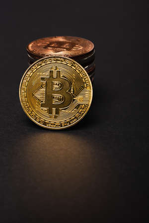 KYIV, UKRAINE - APRIL 26, 2022: Close up view of golden bitcoin near cryptocurrency on black backgroundのeditorial素材