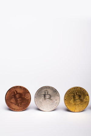 KYIV, UKRAINE - APRIL 26, 2022: Close up view of different bitcoins on white background with copy spaceのeditorial素材