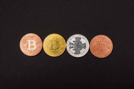 KYIV, UKRAINE - APRIL 26, 2022: Top view of different bitcoins isolated on blackのeditorial素材
