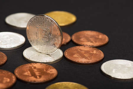 KYIV, UKRAINE - APRIL 26, 2022: Close up view of different bitcoins on black backgroundのeditorial素材