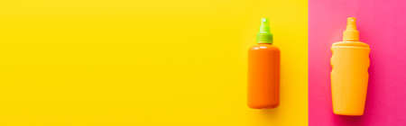 Top view of sunblock in bottles on pink and yellow background, banner