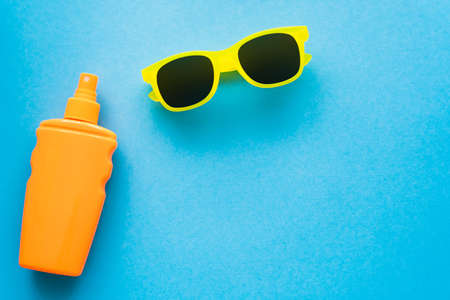 Top view of sunscreen and sunglasses on blue backgroundの写真素材