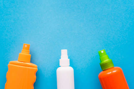Top view of bottles of sunblock on blue background