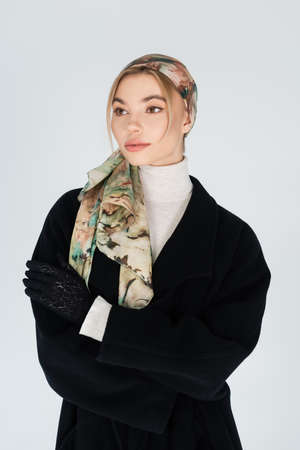 fashionable woman in headscarf looking away isolated on grey