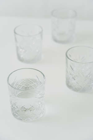 high angle view of glasses with clean water on grey blurred background