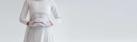 cropped view of bride in gloves and wedding dress isolated on grey, bannerの写真素材