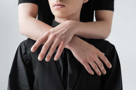 Cropped view of man hugging boyfriend isolated on greyの写真素材