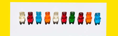 Top view of line from jelly bears on white and yellow, banner