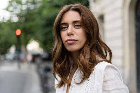 Stylish woman looking at camera on urban street in Parisの写真素材