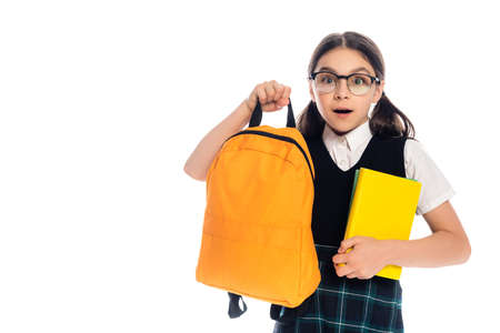 Shocked schoolkid holding books and backpack isolated on whiteの写真素材