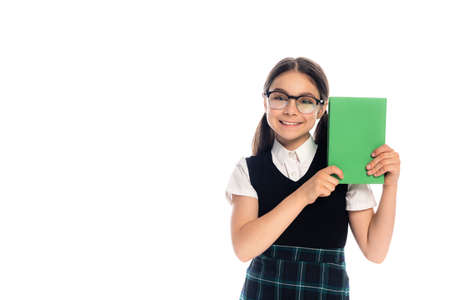 Positive schoolkid in eyeglasses holding book isolated on whiteの写真素材