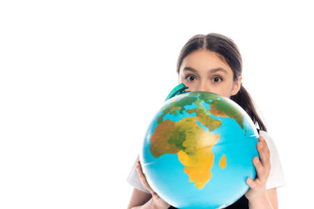 Schoolkid holding globe near face and looking at camera isolated on whiteの写真素材