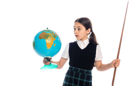 Shocked schoolgirl holding pointer and looking at globe isolated on whiteの写真素材