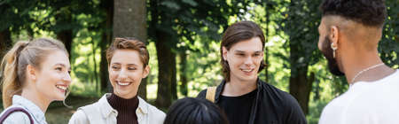 Interracial students smiling and talking in summer park, banner