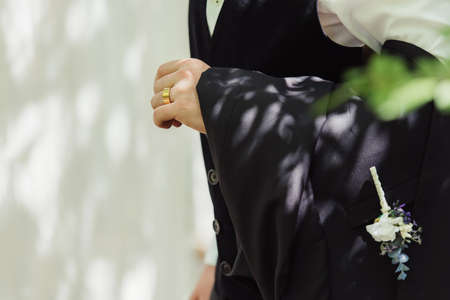 cropped view of groom in formal wear with golden wedding ring on fingerの写真素材
