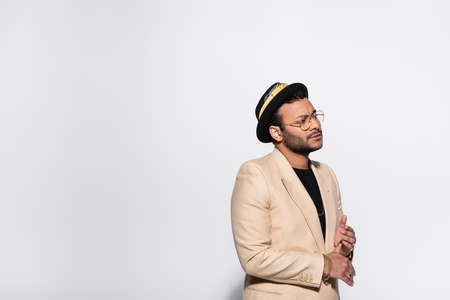 bearded indian hip hop singer in fedora hat and eyeglasses isolated on greyの写真素材