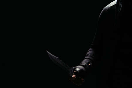Cropped view of african american bandit holding knife isolated on blackの写真素材