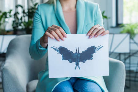 Cropped view of psychologist holding Rorschach test in consultation roomの写真素材