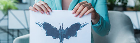 Cropped view of psychologist holding Rorschach test in consulting room, bannerの写真素材