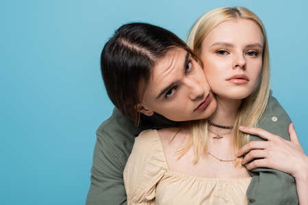 Portrait of stylish young couple looking at camera isolated on blueの写真素材