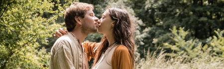 Side view of brunette woman kissing husband in summer forest, banner