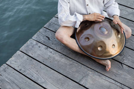 Cropped view of musician performing handpad on wooden pierの写真素材