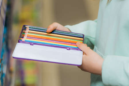 partial view of child holding set of new color pencilsの写真素材