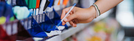cropped view of woman in beaded bracelets trying ball pen in stationery store, bannerの写真素材
