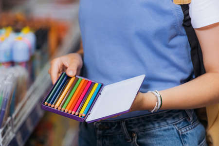 partial view of woman in beaded bracelets holding set of color pencilsの写真素材