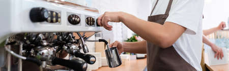 Cropped view of african american saleswoman making coffee near machine in confectionery, banner