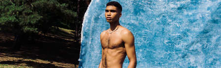 shirtless african american man in beads near blue cloth in park, bannerの写真素材