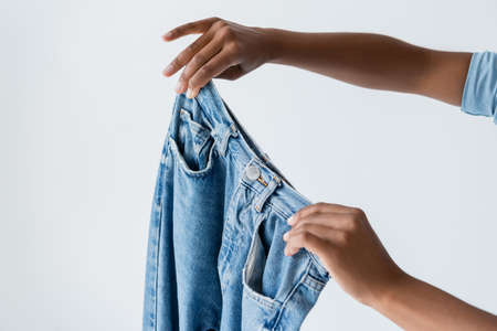 cropped view of african american woman showing jeans isolated on greyの写真素材