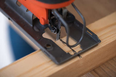 Close up view of electric jigsaw machine and wooden plankの写真素材
