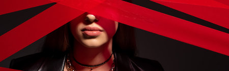 red strips from duct tape near teenage model isolated on black, bannerの写真素材
