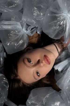 top view of brunette model lying around plastic bags, recycle fashion conceptの写真素材
