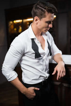 Man in shirt standing near bar in eveningの写真素材