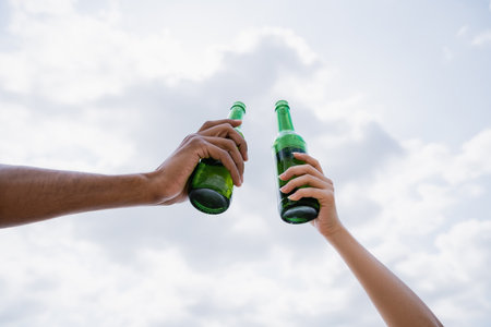 partial view of multiethnic friends toasting with fresh beerの写真素材