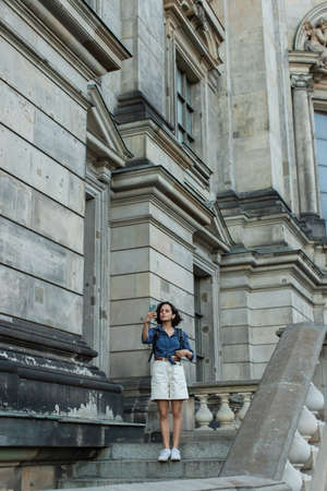 full length of tourist taking selfie on smartphone in front of building in berlin