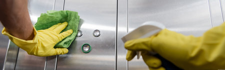 partial view of man in rubber gloves cleaning office elevator with rag, banner