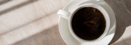 top view of cup of black coffee and white saucer on marble surface, bannerの写真素材