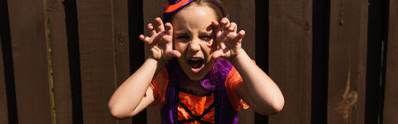 girl in halloween costume growling and showing scary gesture, bannerの写真素材