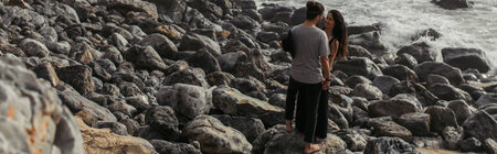 tattooed woman smiling and looking at boyfriend near ocean in portugal, bannerの写真素材